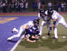 Justin Colbaugh sacks QB Rometo at the 1 with Loheyde and Kwaitkowski nearby.